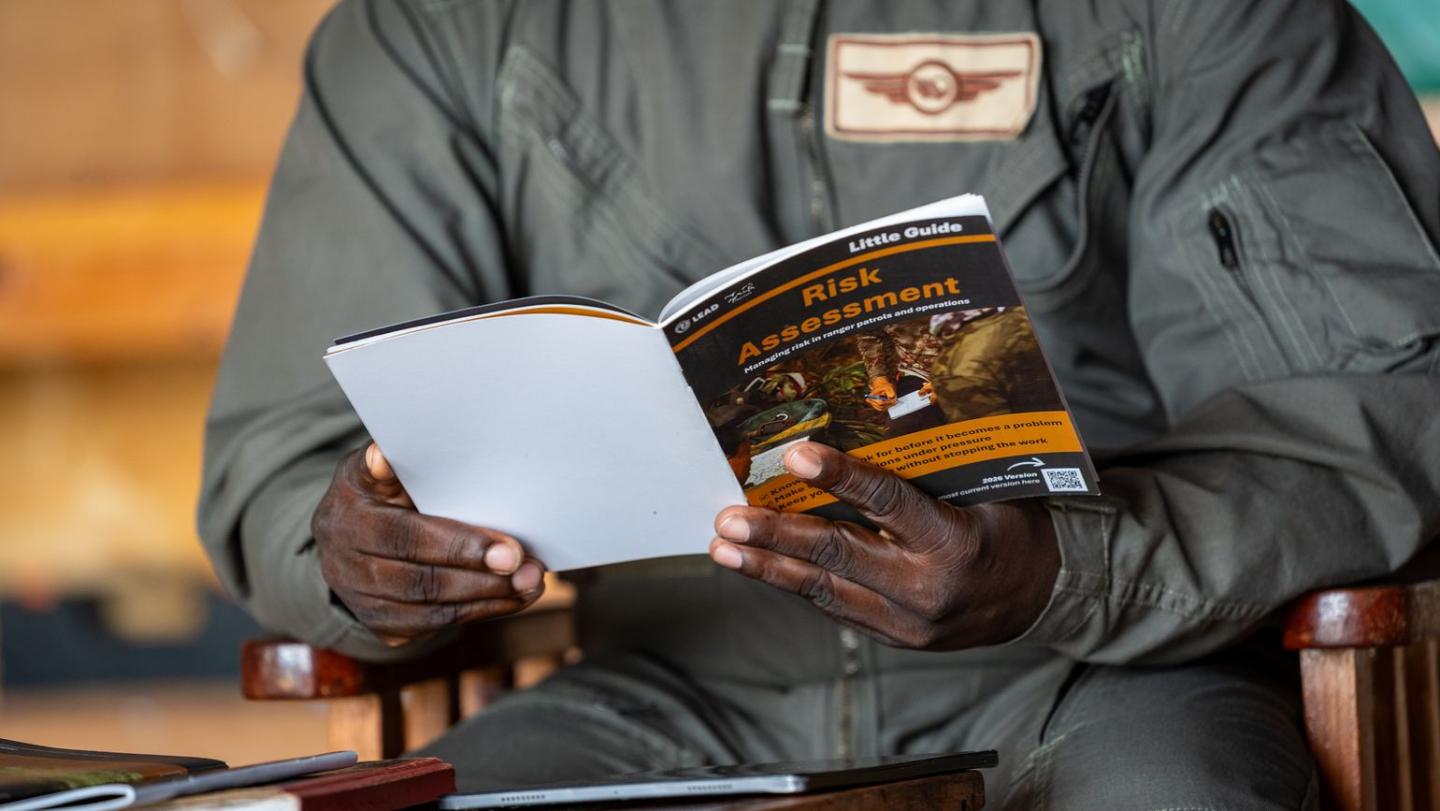Person holding a printed Little Guide