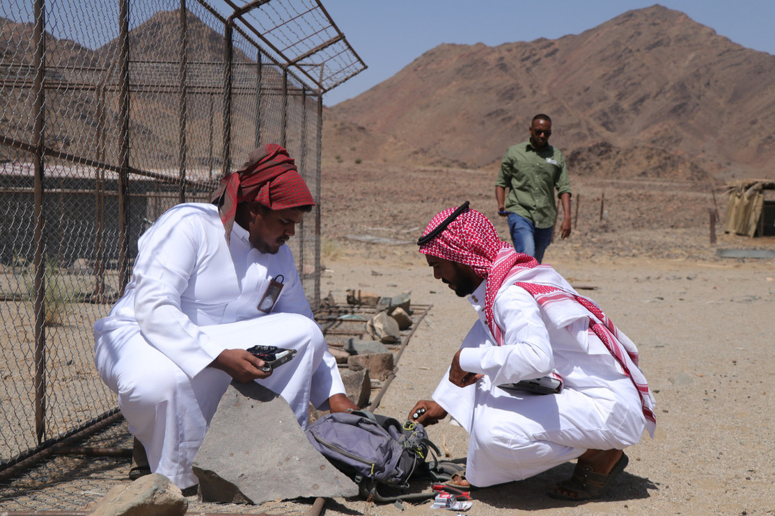 Community Liasion Officers deploy remote cameras at a predator-proof enclosure.